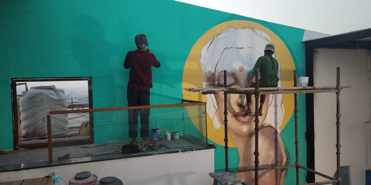 Aftab painting a mural in Noida