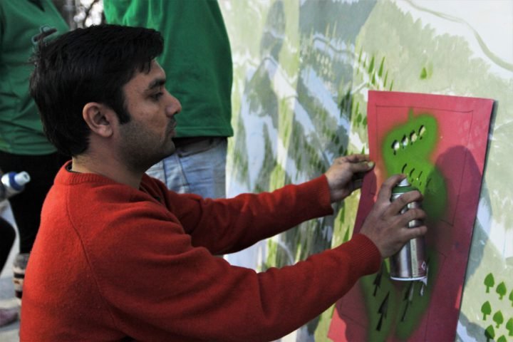 Zain paints a waste mural in Dharamshala