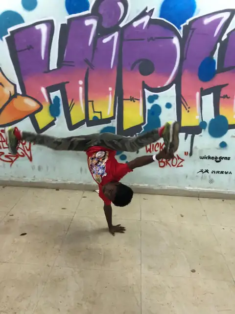 hip hop talent posing at wall art graffiti designed by wicked broz for bombway fest9