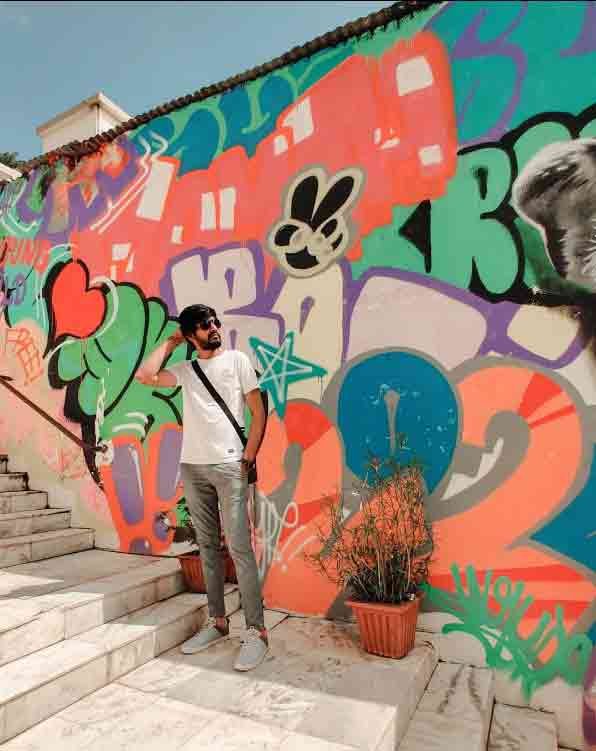 Man posing in front of graffiti at Hotel Mamta Palace, Mount Abu, Rajasthan