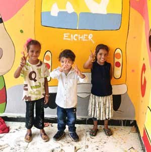 Toddlers in front of a school wall art workshop